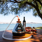 Storz & Bickel Volcano Hybrid Vaporizer auf einem Tisch am Wasser, ideal für Kräuter und Extrakte.